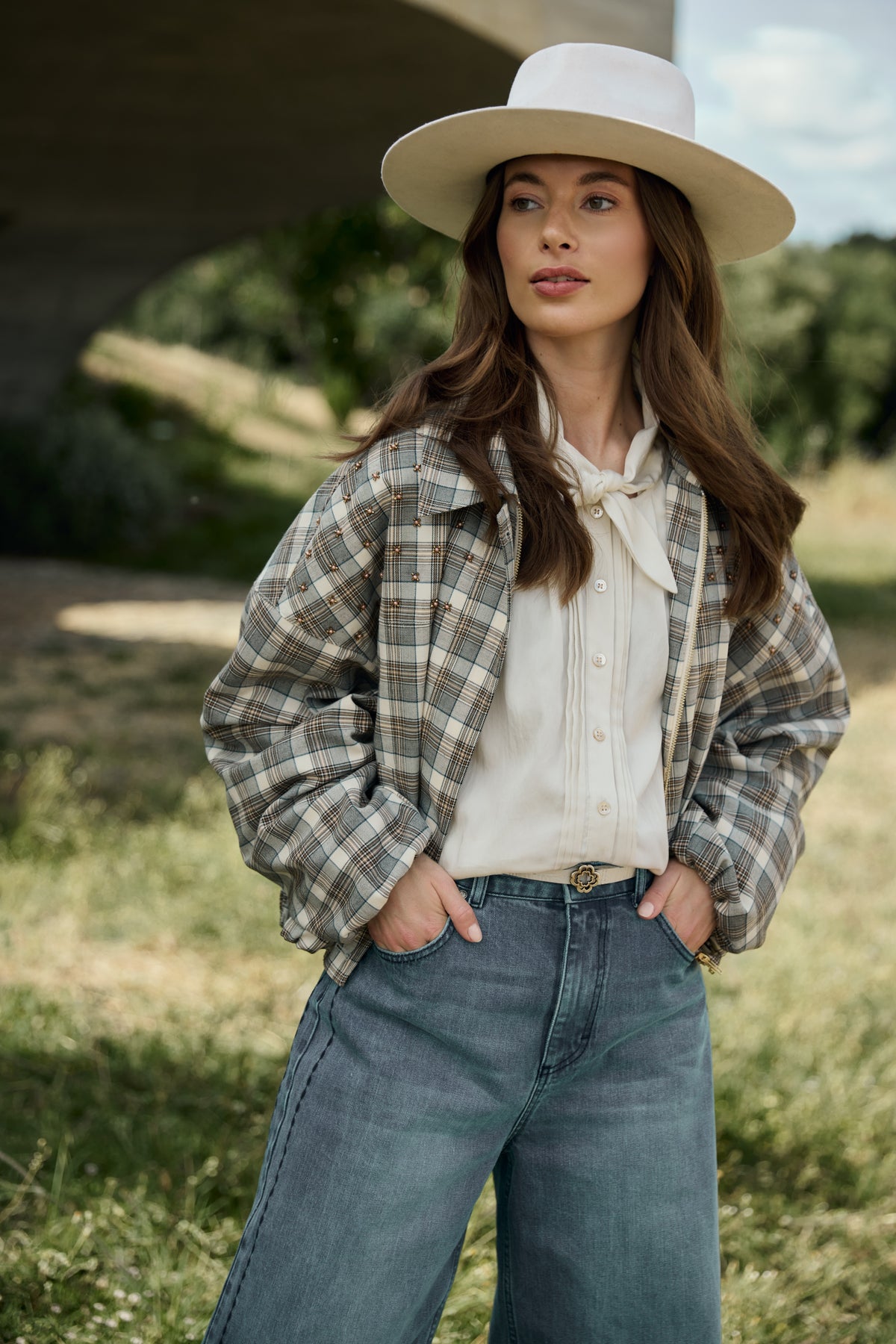 Offwhite blouse Alexandra van Nukus met lange mouwen en ronde hals, gelegen op een witte achtergrond.