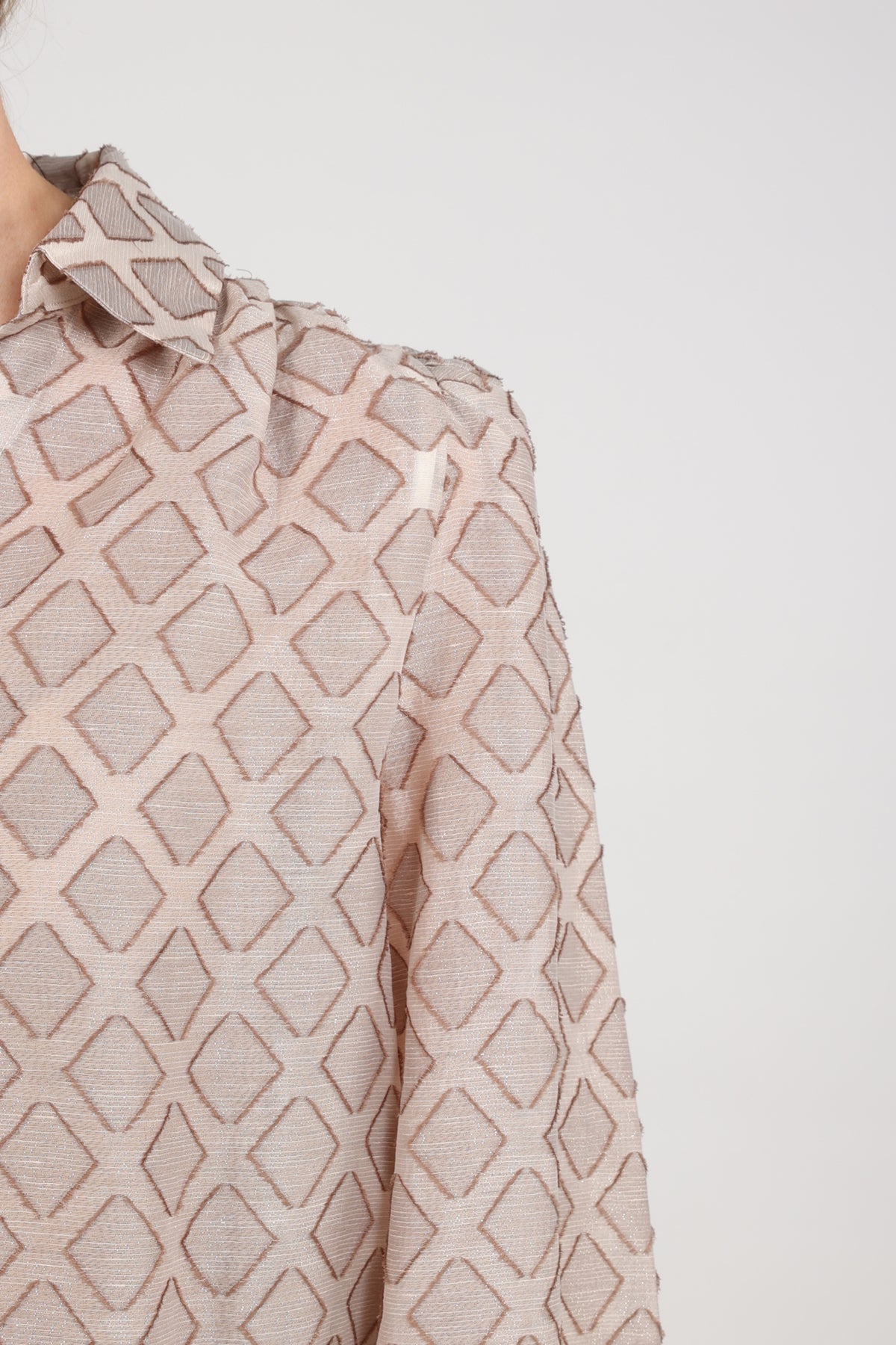 Nukus Antonella patroon blouse in zandkleur met kleurrijk design, korte mouwen en knoopsluiting, gedragen door een model.