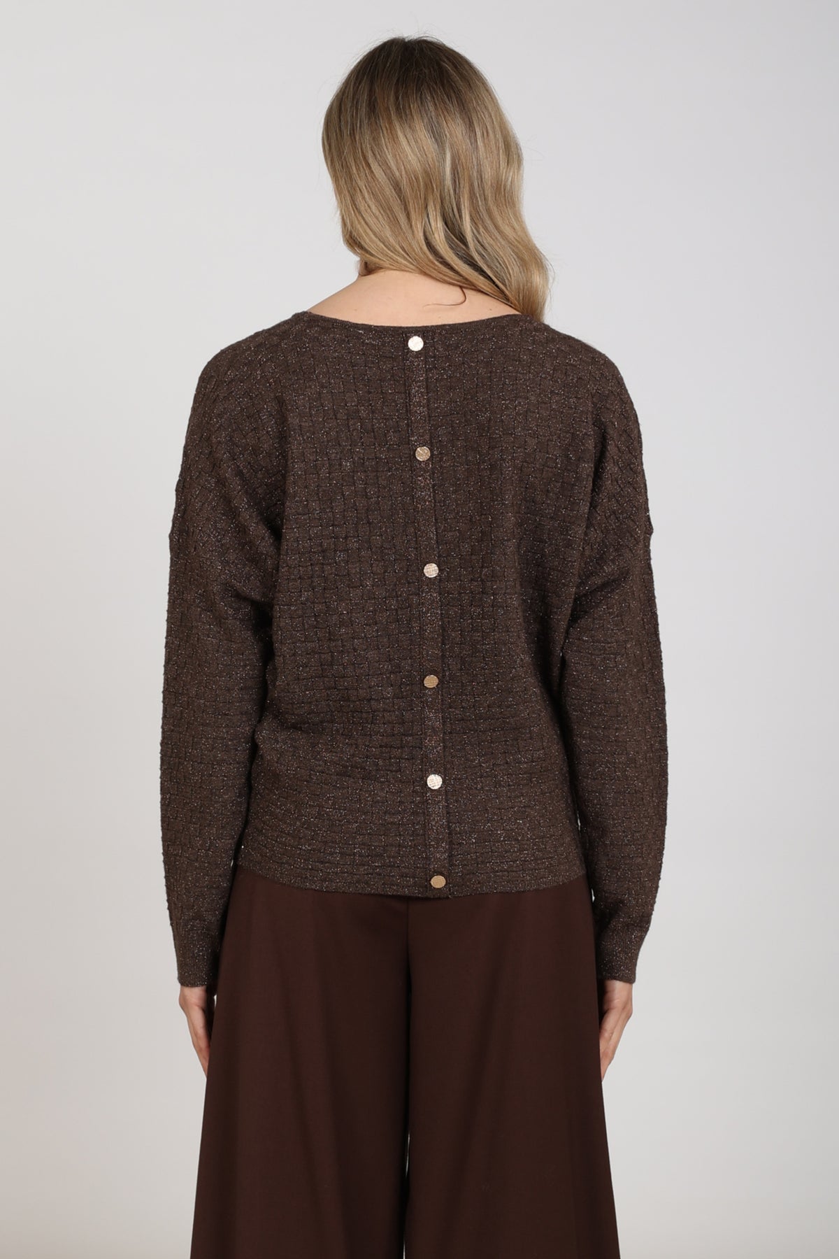 Nukus Kento lurex top in chocoladekleur, glanzende stof met sierlijke pasvorm, op model gedragen.