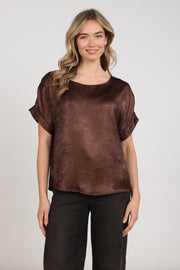 Nukus Top Irene Shiny Chocolate NKF01024, glanzende chocoladekleurig top met elegante snit, getoond op model.