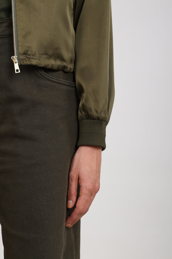 Nukus Dena Shiny Moss jas met glanzende afwerking en ritssluiting, gedragen door een model op een witte achtergrond.