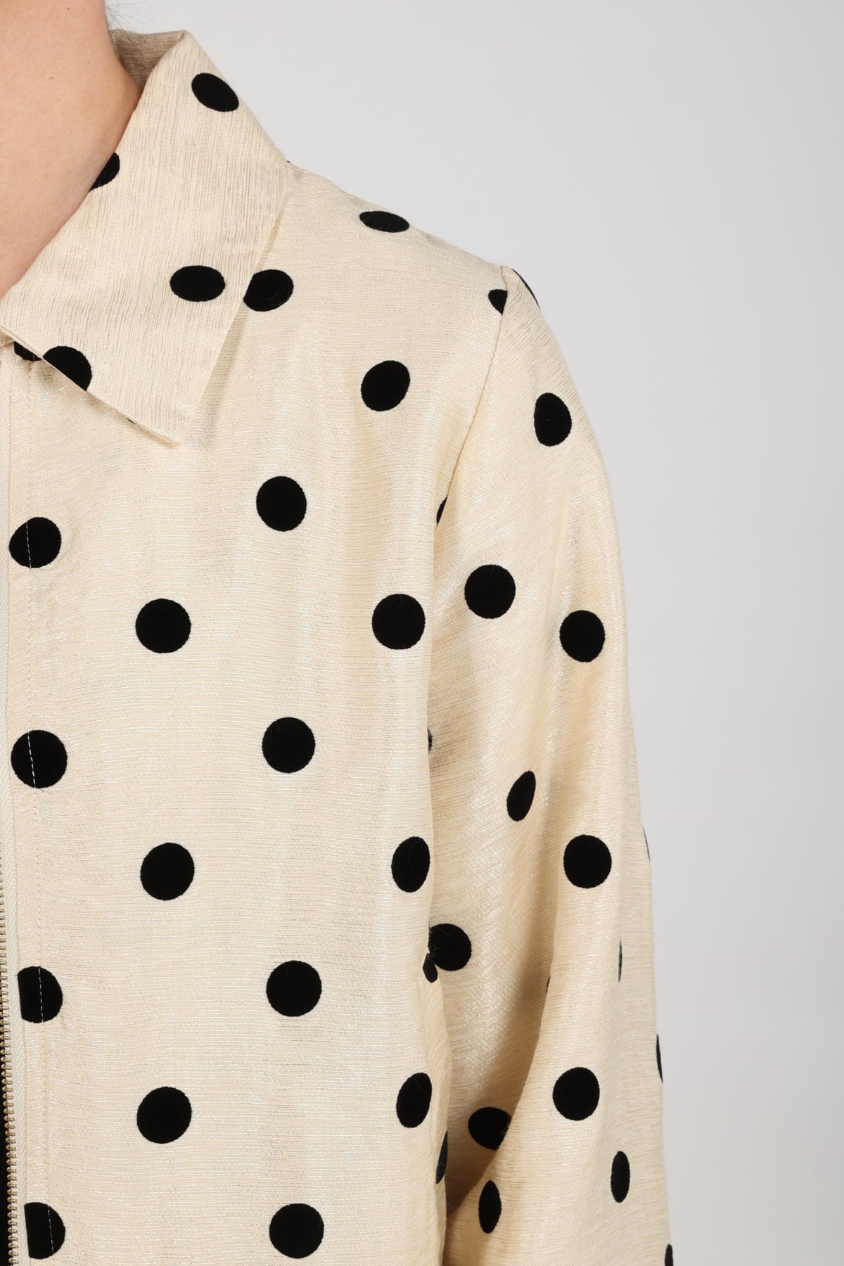 Nukus Noa Dots jas in offwhite en zwart met speelse polkadots en comfortabele pasvorm, zichtbaar in de afbeelding.