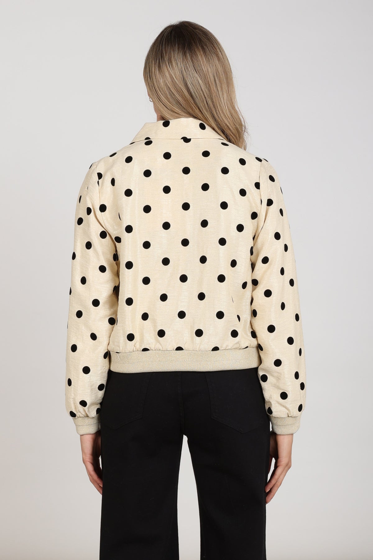 Nukus Noa Dots jas in offwhite en zwart met stippen, korte stijl en knoopsluiting, op een model gedragen.