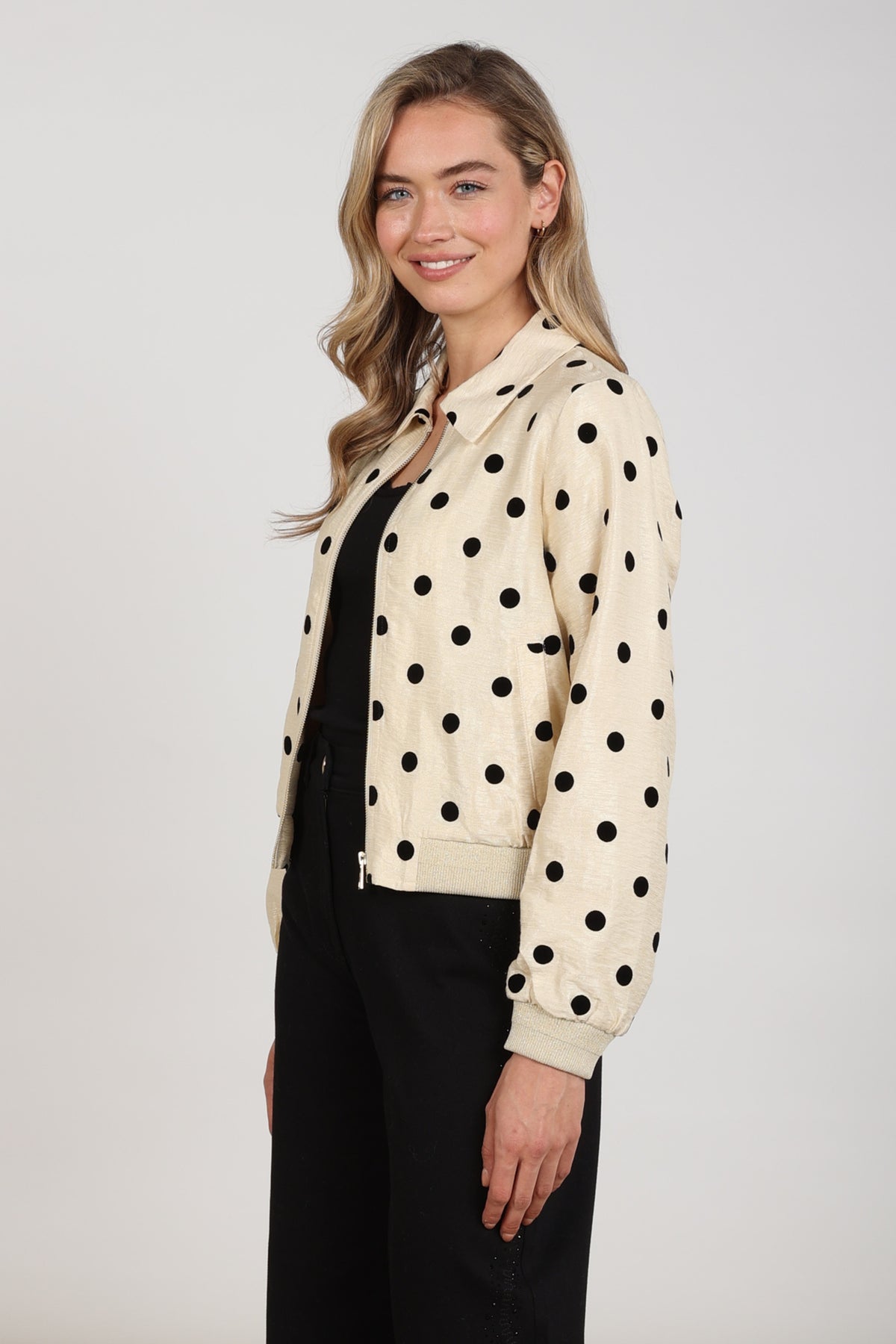 Lichte Noa Dots jas van Nukus in offwhite en zwart met een speelse dotted print, gedragen door model.