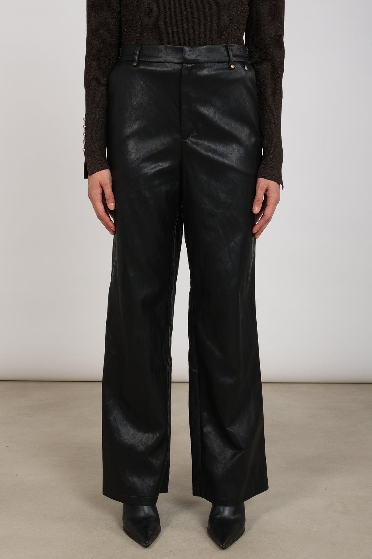 Zwarte Nukus Beverly Pockets PU broek met zakken, casual stijl, gedragen door een model, close-up van de stof en pasvorm