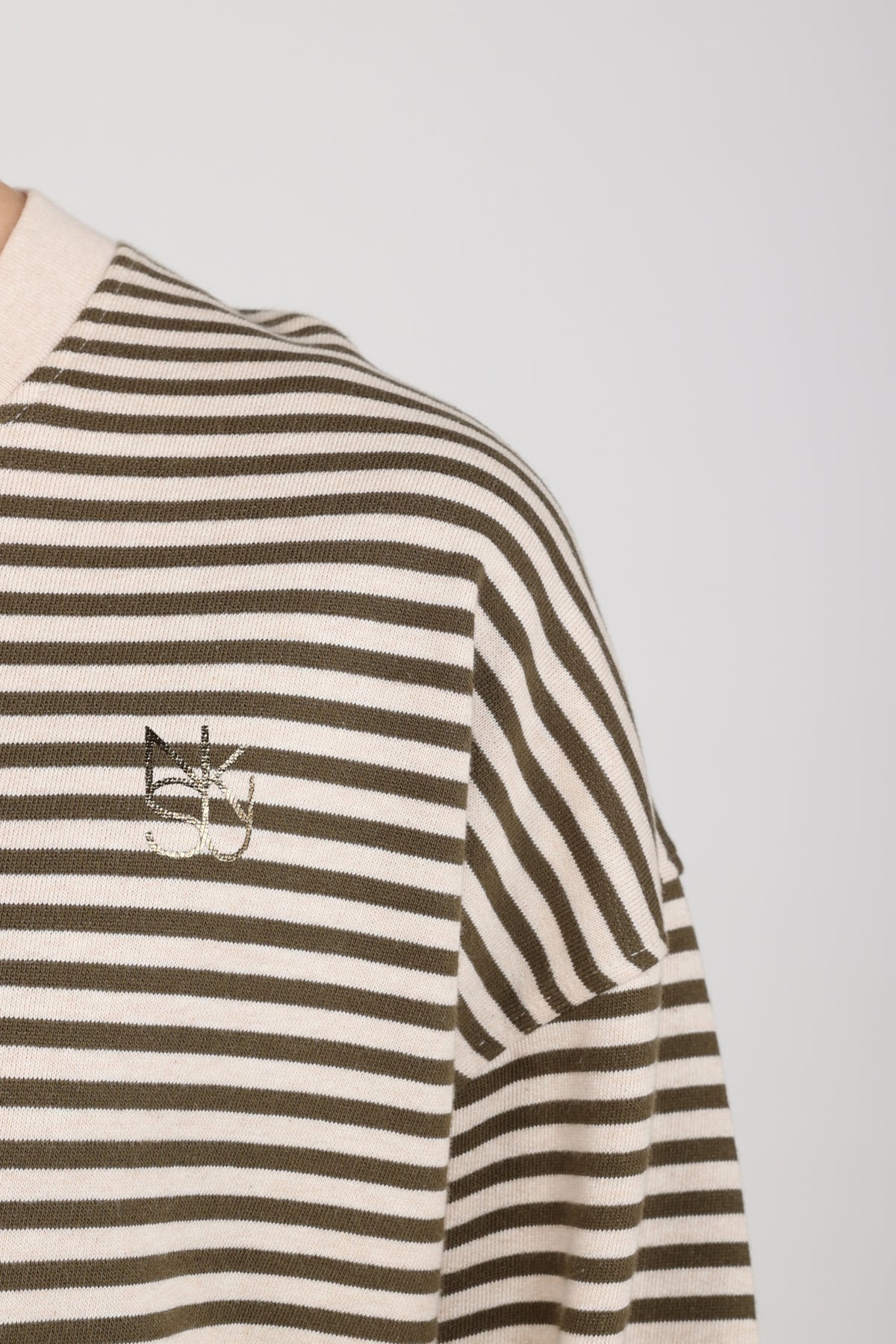 Nukus Nelly Stripe Sand Melange trui met fijne strepen en zachte textuur, gedragen door een model op een neutrale achtergrond.