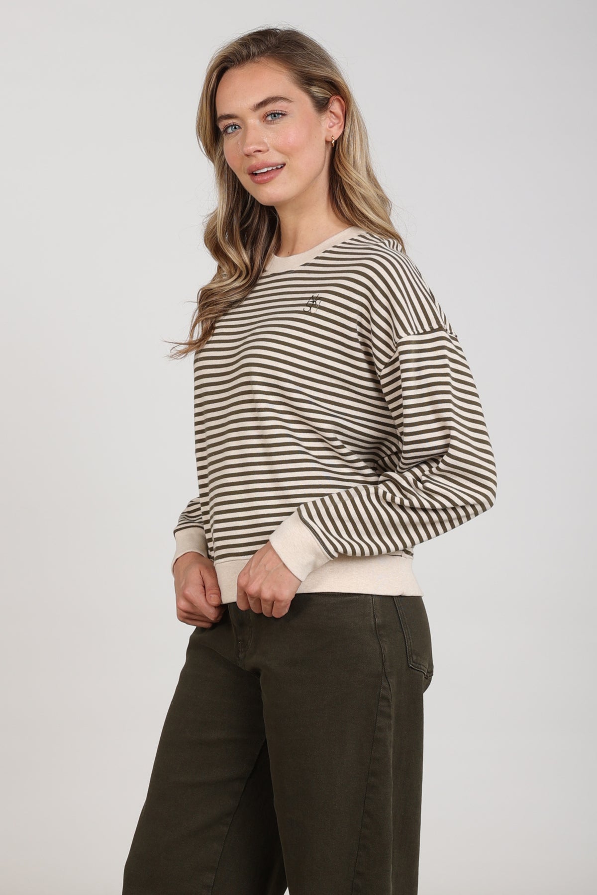Lichtgrijze en zandkleurige gestreepte trui van Nukus, Nelly Stripe Sand Melange, gedragen door een model.