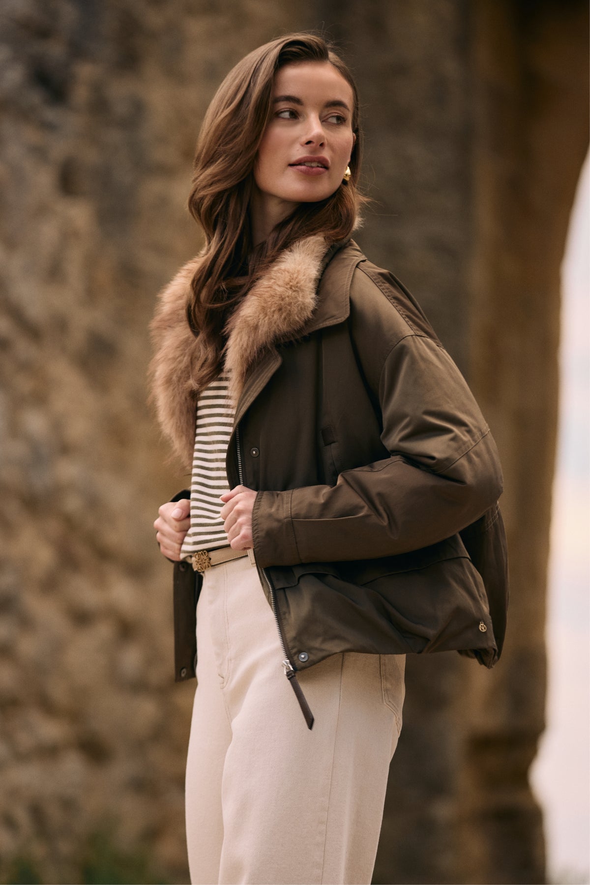 Nukus Trui Nelly Stripe Sand Melange met dunne strepen en zachte textuur, gedragen door een model, close-up van de stof en pasvorm.
