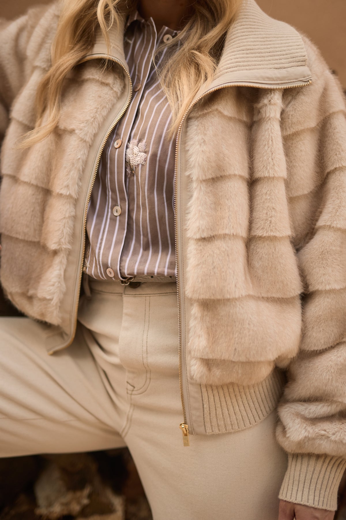 Nukus Manuela Sand jacket voor dames, lichtgewicht en casual, getoond op een model met openstaande rits en capuchon.