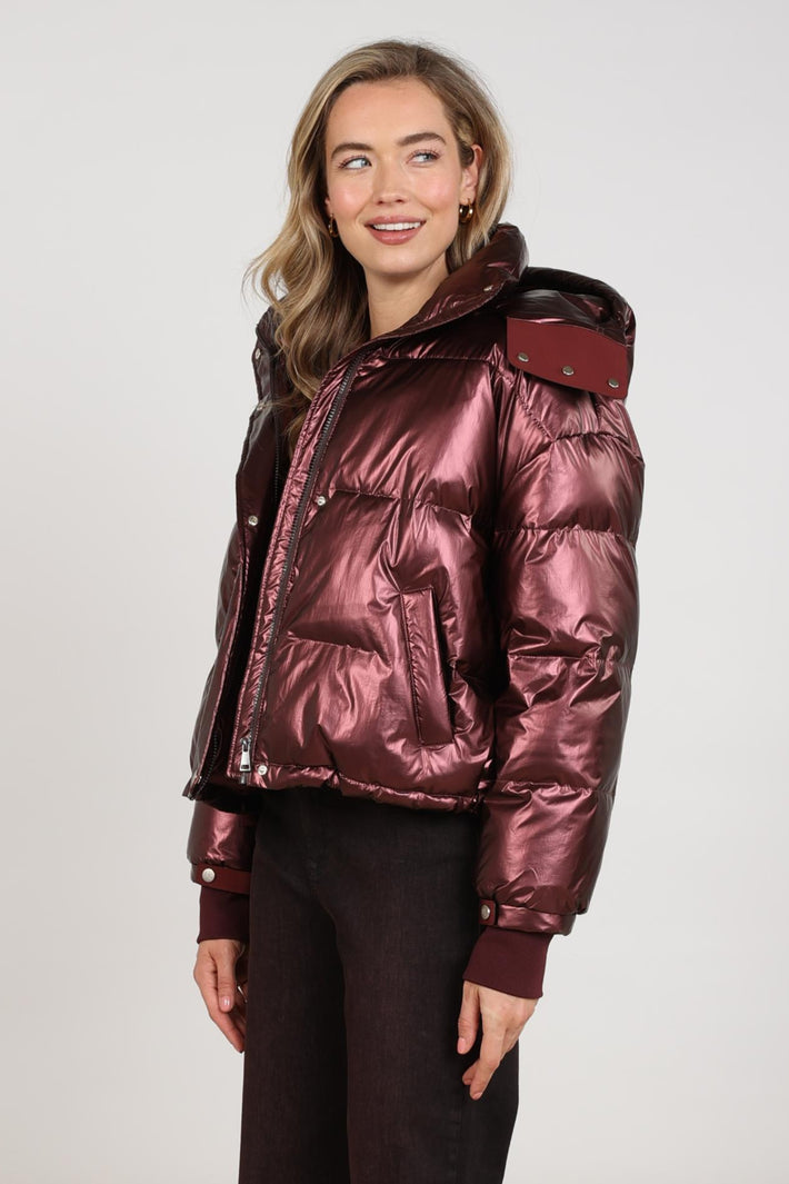 Nukus Melodi Metallic Cherry jas met glanzende metallic afwerking en stijlvolle pasvorm, zichtbaar op de afbeelding.