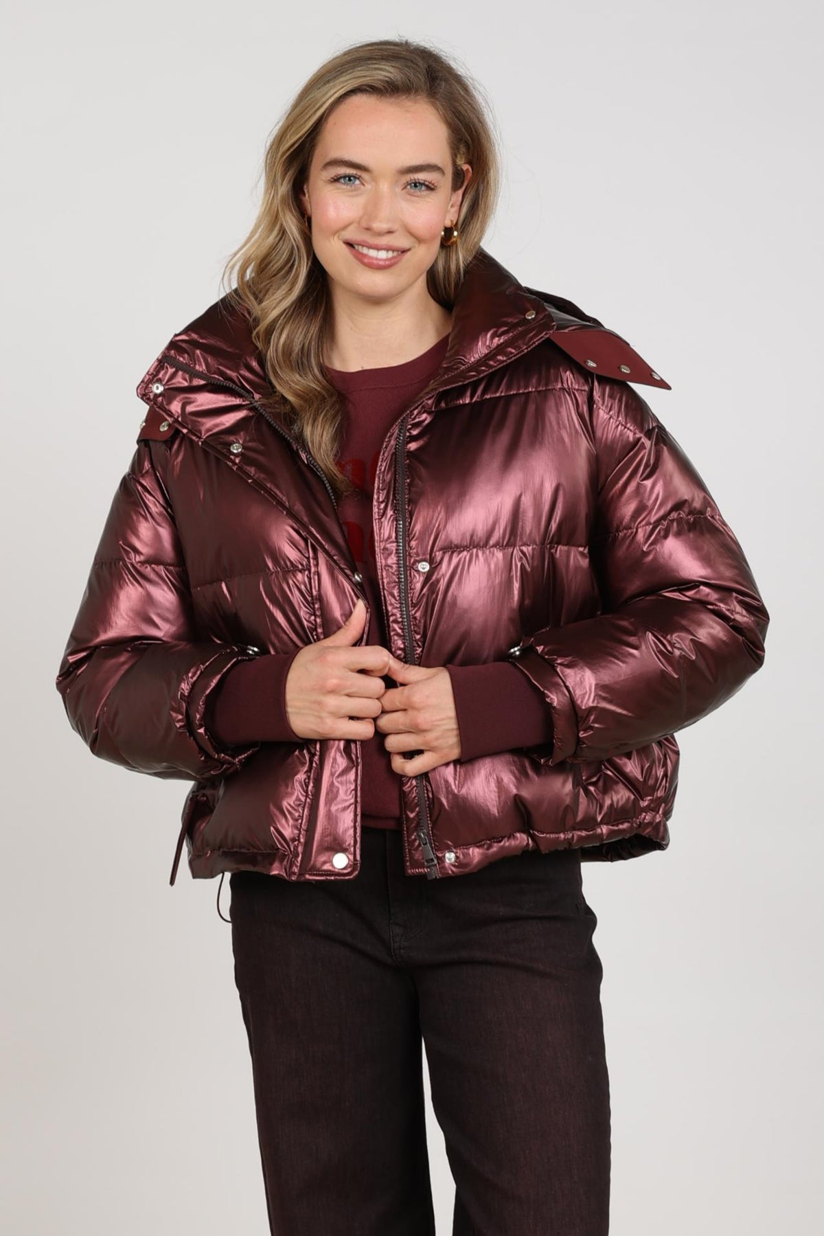 Nukus Melodi Metallic Cherry jas met glanzende rode afwerking en ritssluiting, gedragen door een model.