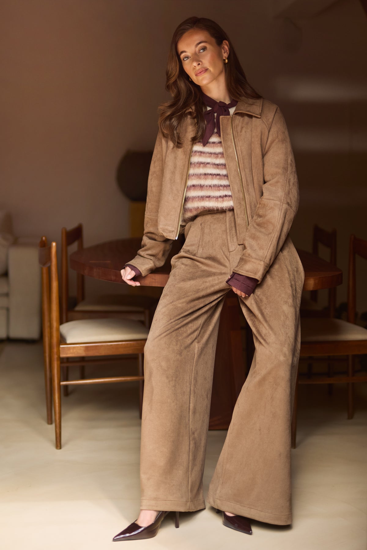 Taupe Nukus Daisey jas met capuchon en ritssluiting, getoond in een stijlvolle pose