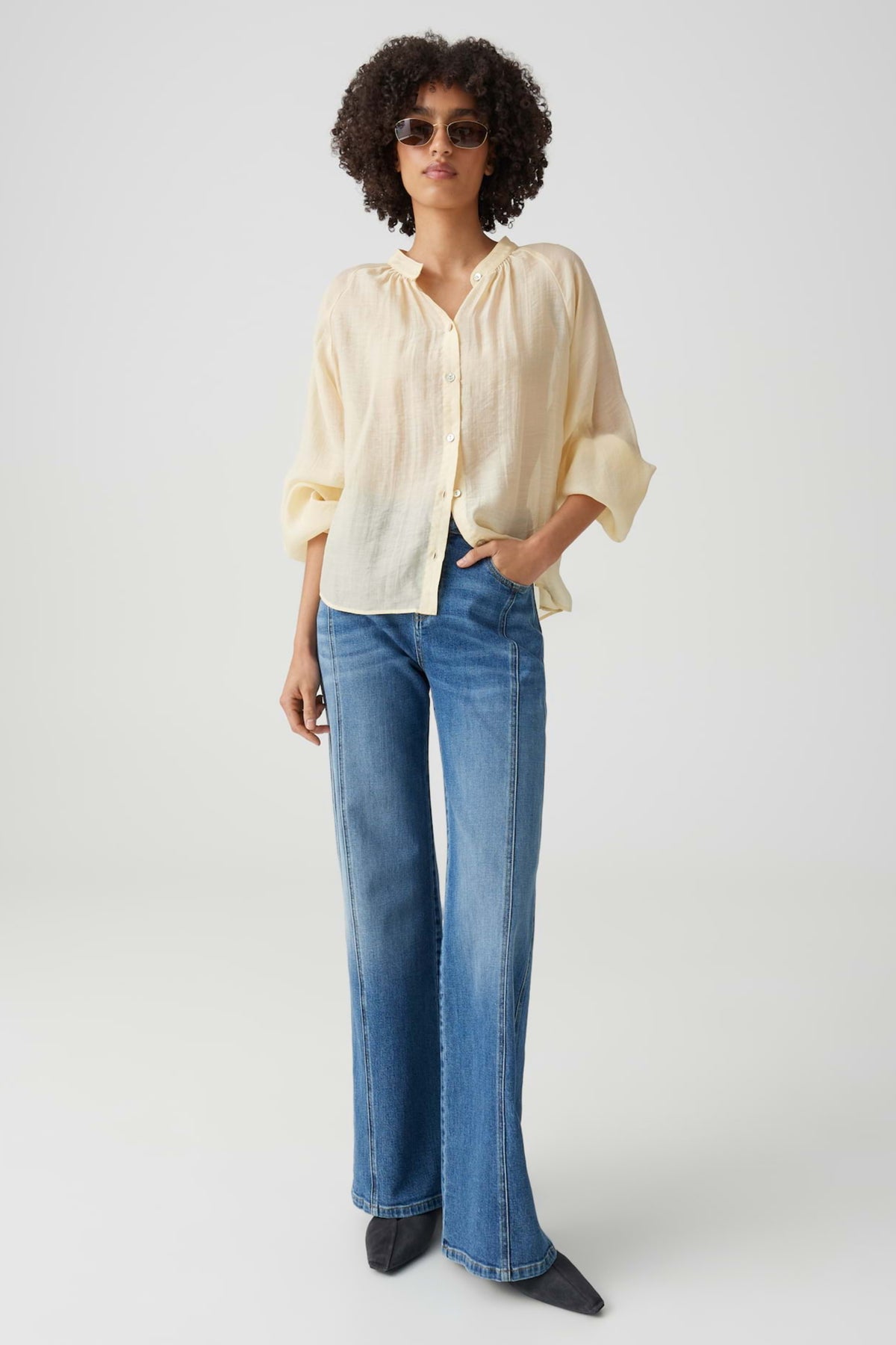 Zachte gele blouse Fabrielle Honey Butter van Opus met losvallende pasvorm en lange mouwen, gedragen door een model.