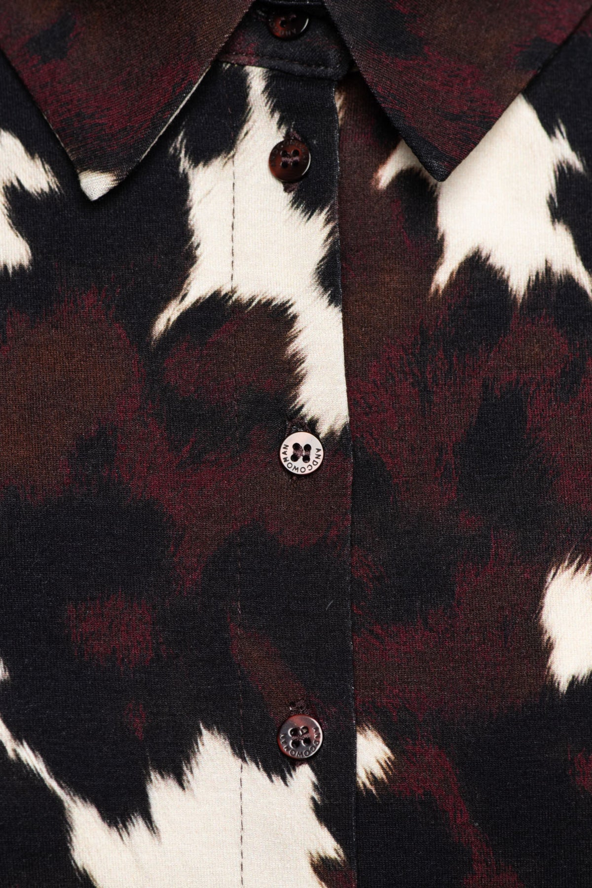 Zwarte blouse Lotte Cow van &Co woman met multicolor details, gedragen door een model, geschikt voor casual en elegante outfits.