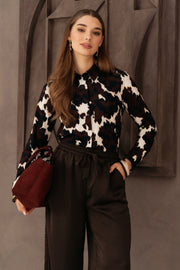 Zwarte blouse Lotte Cow van &Co woman met multicolor details, getoond in een modieuze close-up foto.