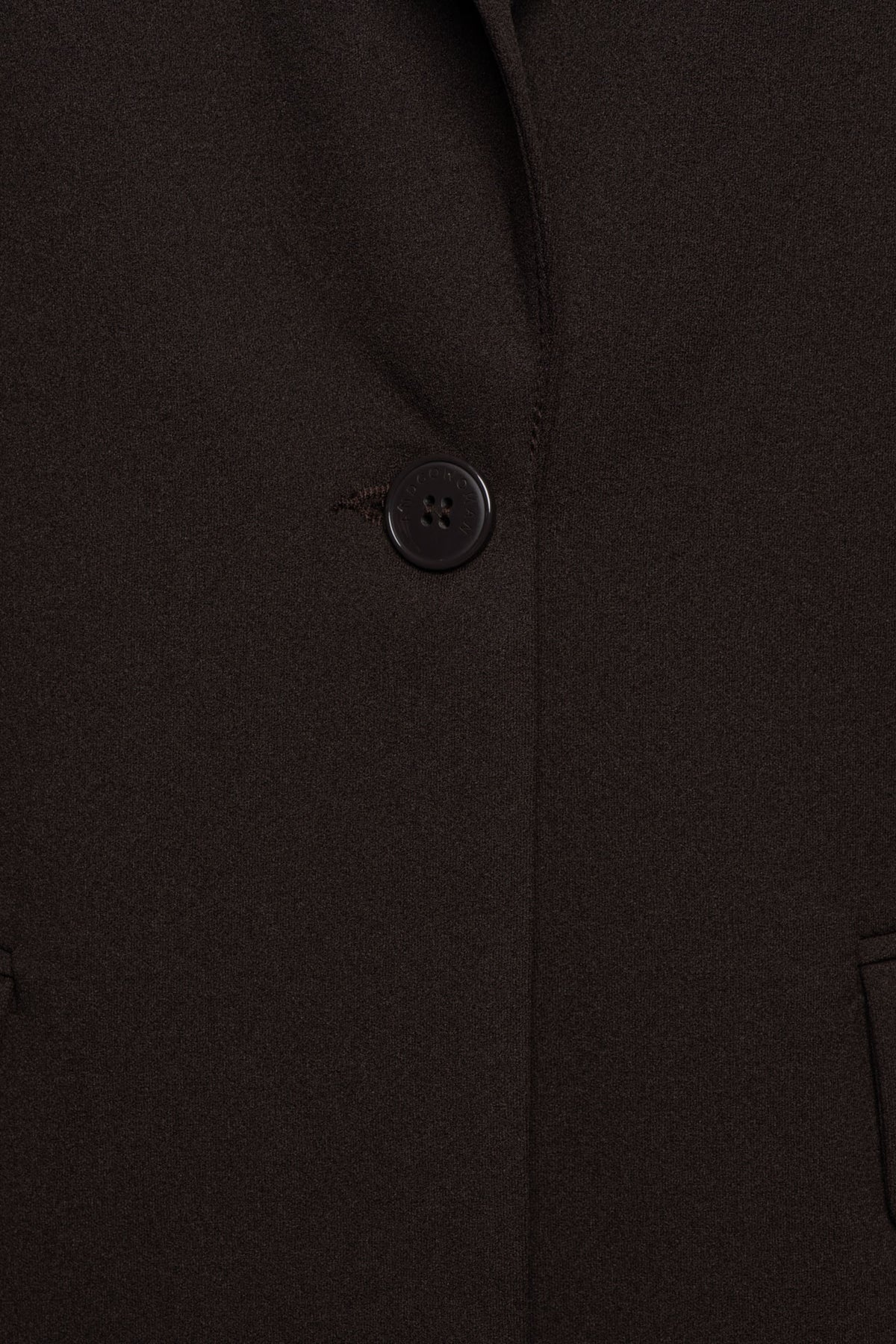 Donkerbruine blazer Glennis van &Co woman, getailleerd met knopen en reverskraag, gedragen door een model.