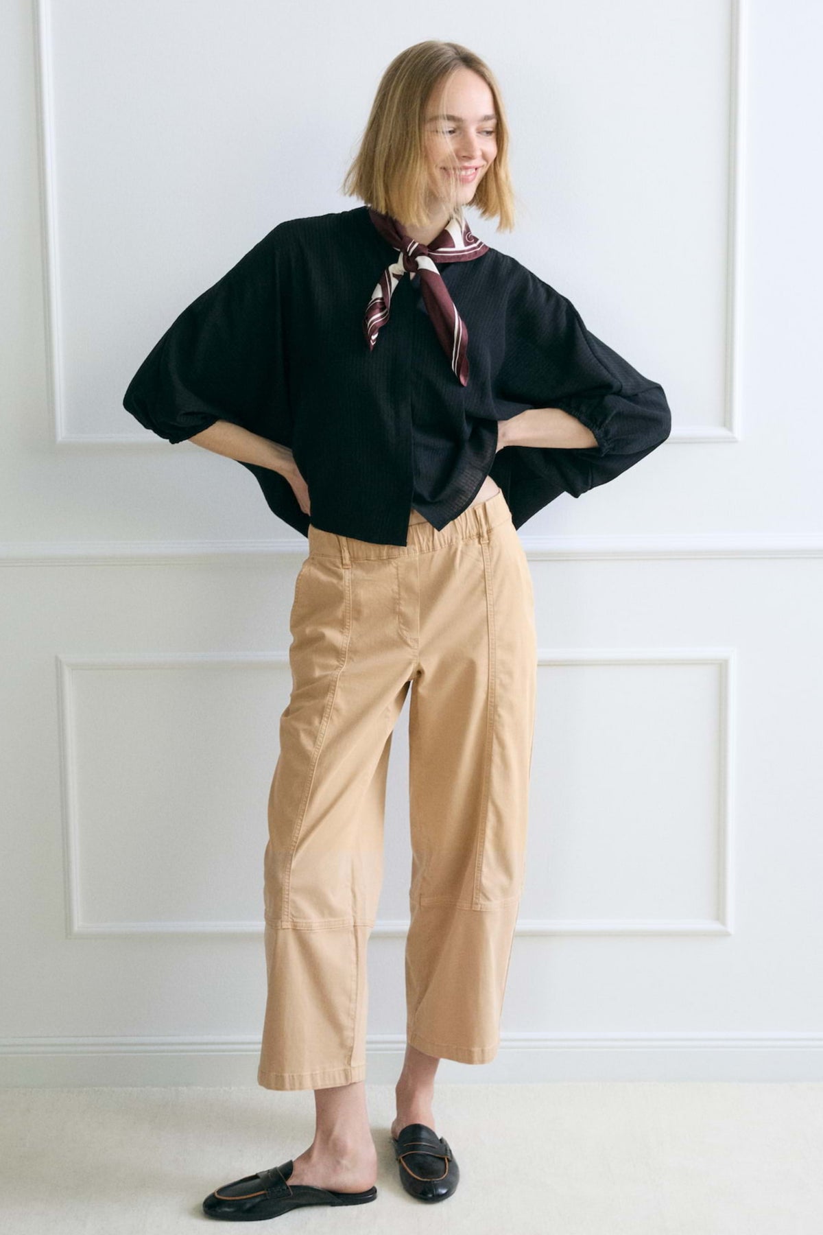 Opus Myha Edit gouden beige broek met rechte snit en elastische taille, gedragen door een model op een witte achtergrond.