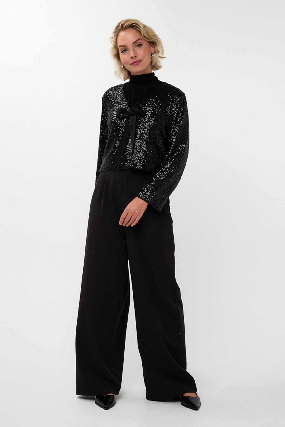 Zwart blazer short Bow van EsQualo, getailleerd model met knoopsluiting en lange mouwen, gedragen door een model.