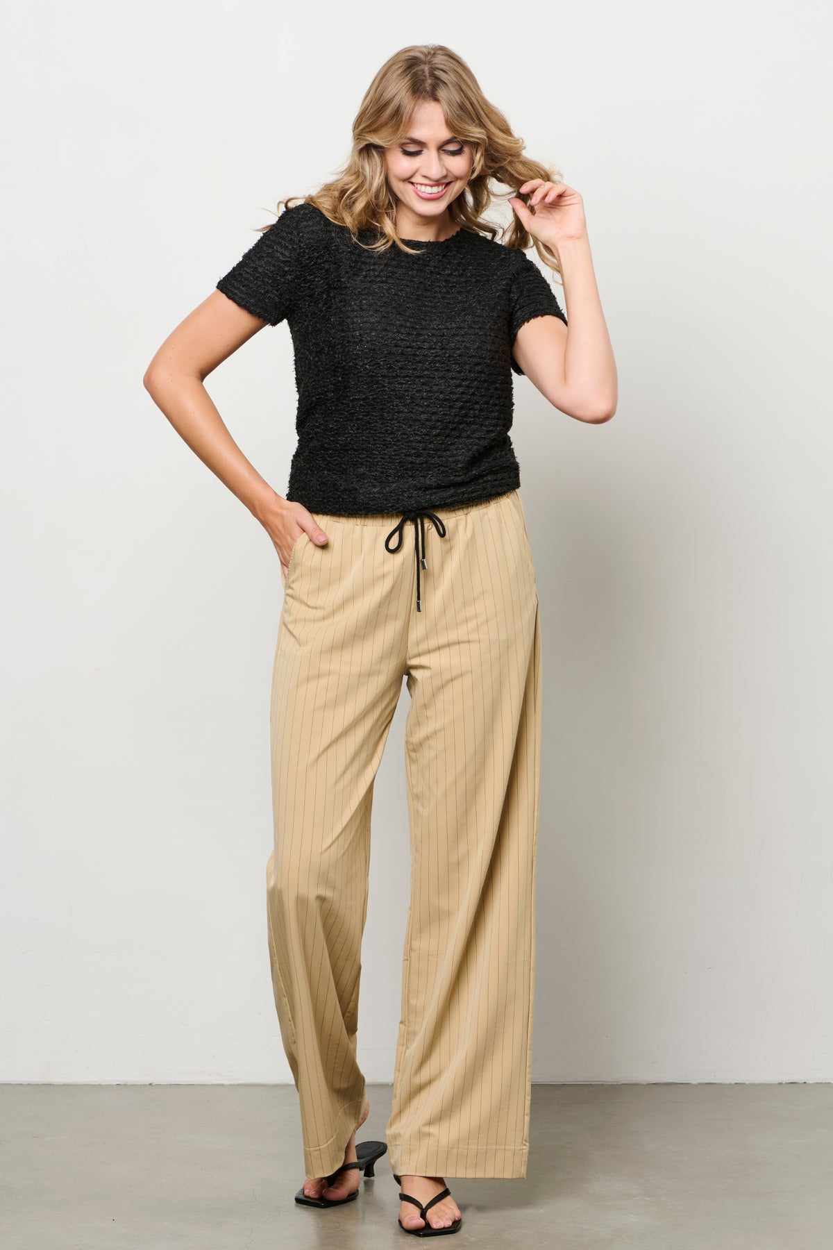 Lichte reisbroek Parisa Stripe Sunset van &Co woman met sierlijke strepen en comfortabele pasvorm, zichtbaar op de afbeelding.