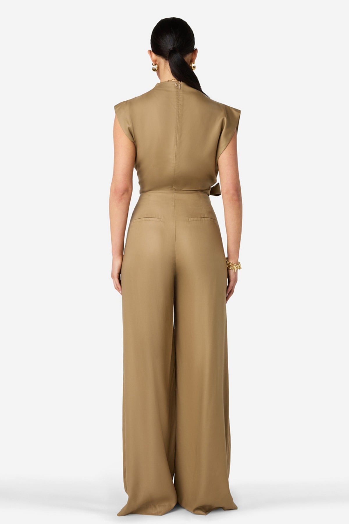 Ibana Top Tavir Terra beige met ronde hals en korte mouwen, zachte stof en casual pasvorm, gelegen op een houten oppervlak.