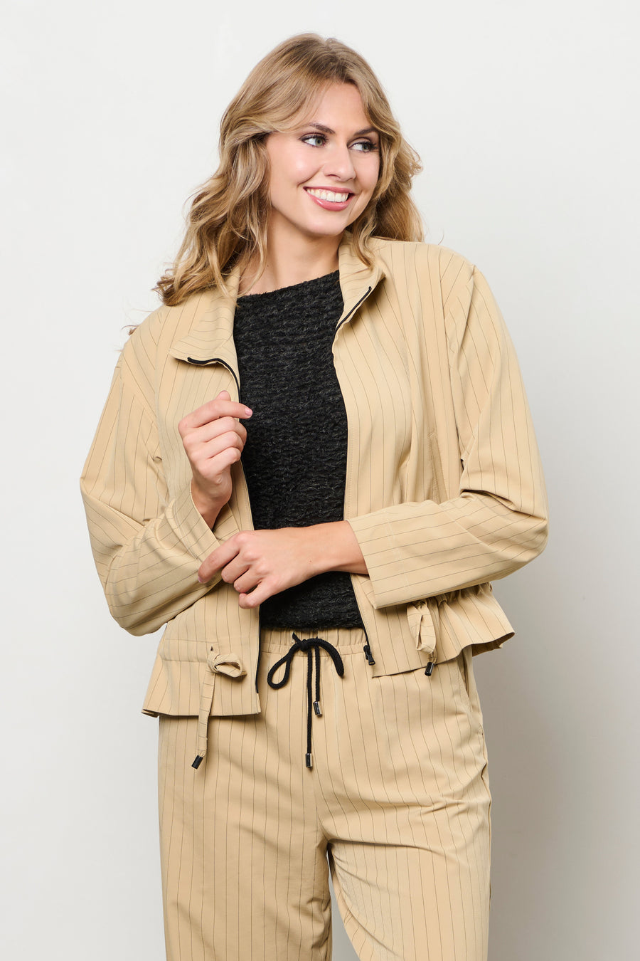 Lichtgewicht reisjacke van &Co woman in stripe sunset patroon, met capuchon en praktische zakken, geschikt voor reizen en buitenactiviteiten.