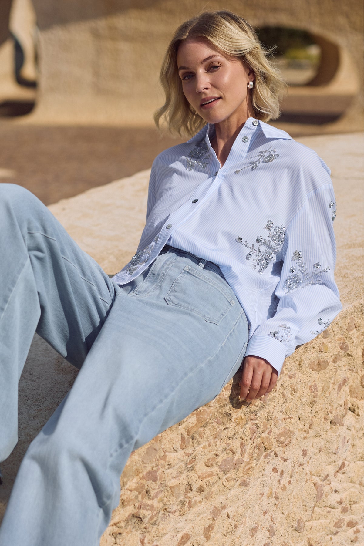 Lichte offwhite blouse Adora Stripe Cloudy van Nukus met gestreept patroon en losse pasvorm, getoond op model.