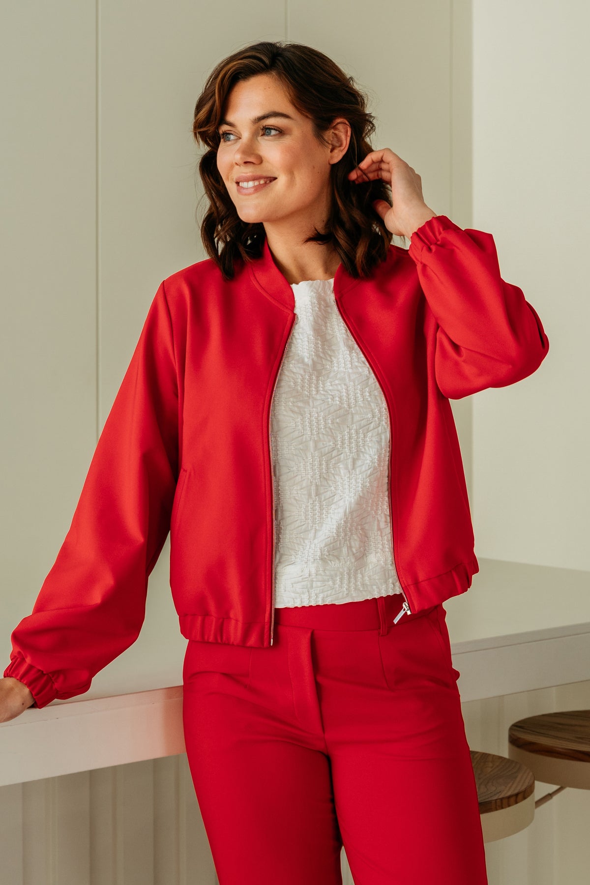 Lichte rode damesjas van &Co woman met capuchon en ritssluiting, geschikt voor herfst en winter.