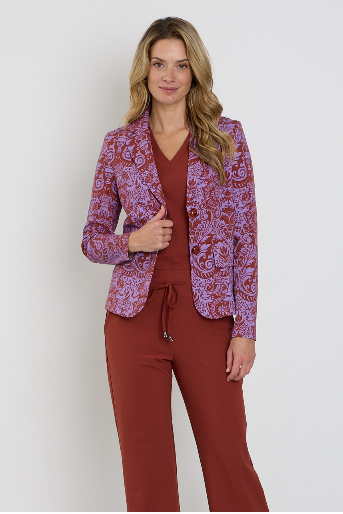 Mi Piace Travel Top in Fired Brick, comfortabel en stijlvol, weergegeven op een model met een neutrale achtergrond.