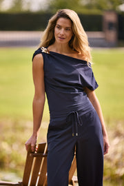 Zwartblauwe Travel Top Broche van Mi Piace, elegante accessoire met navykleurige details, zichtbaar op een witte achtergrond.