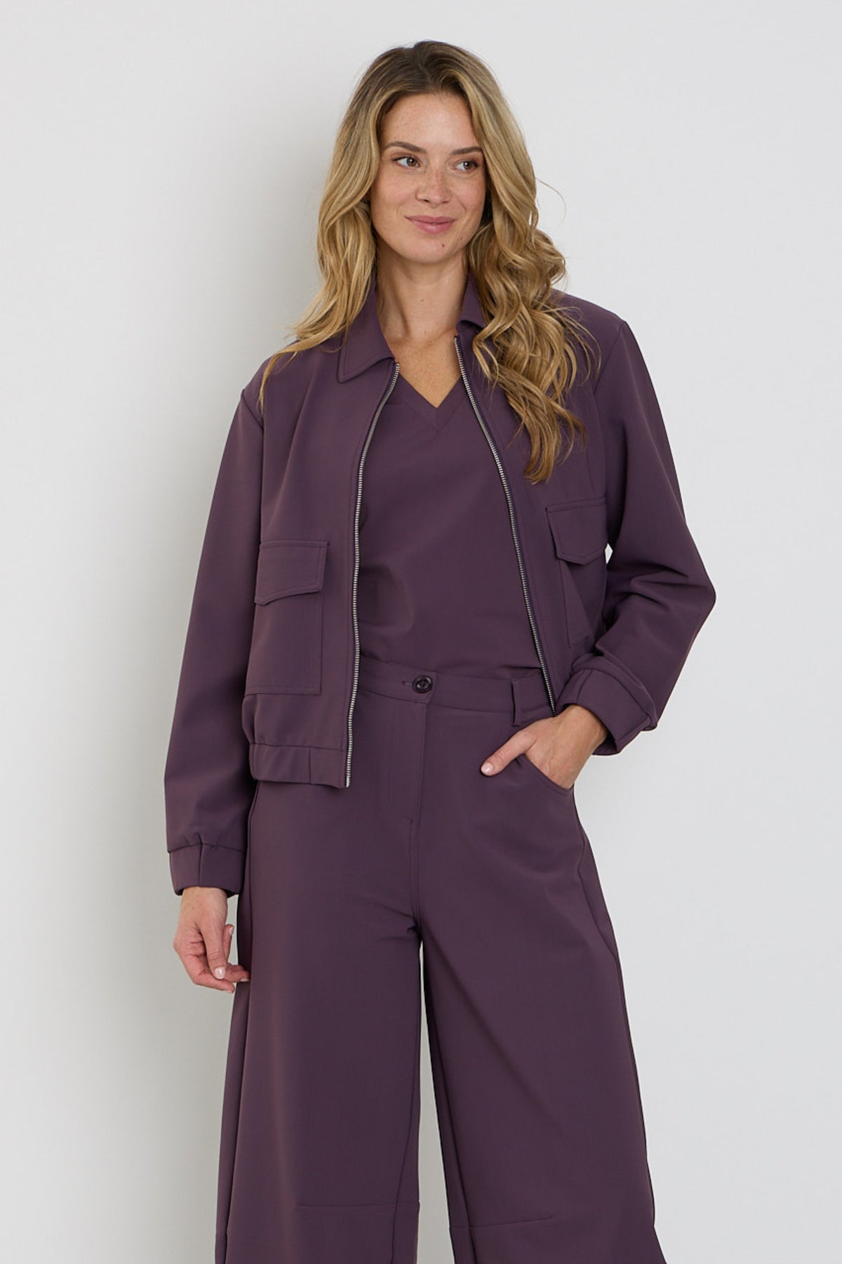 Mi Piace Travel Top Plum Perfect, lichtgewicht top in paarse kleur, gedragen door een model voor een stijlvolle look.