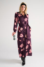 Lange maxi jurk van K-design met bloemenprint, vloeiende stof en elegante uitstraling, gedragen door een model.