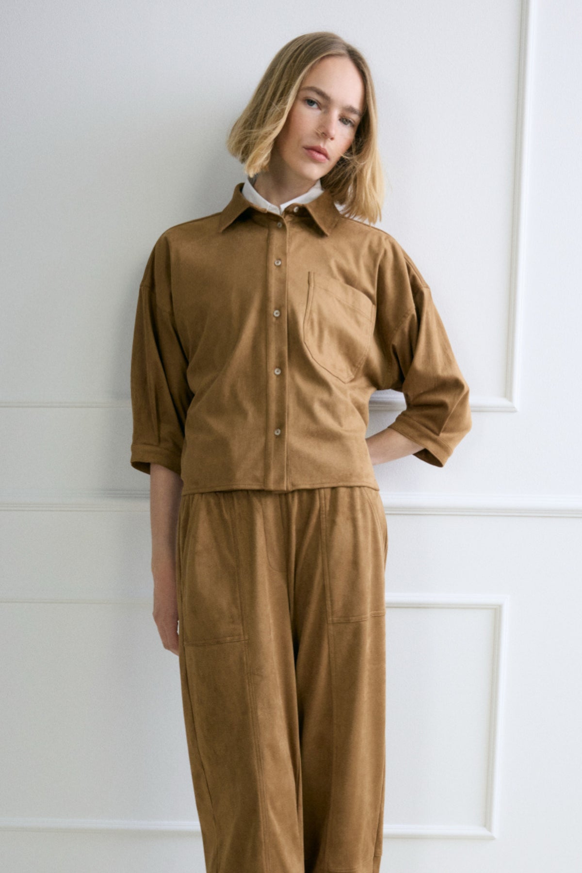 Opus blouse Faloura Ginger Bread met lange mouwen en ronde hals, gemaakt van zachte, bruine stof, gedragen door een model.