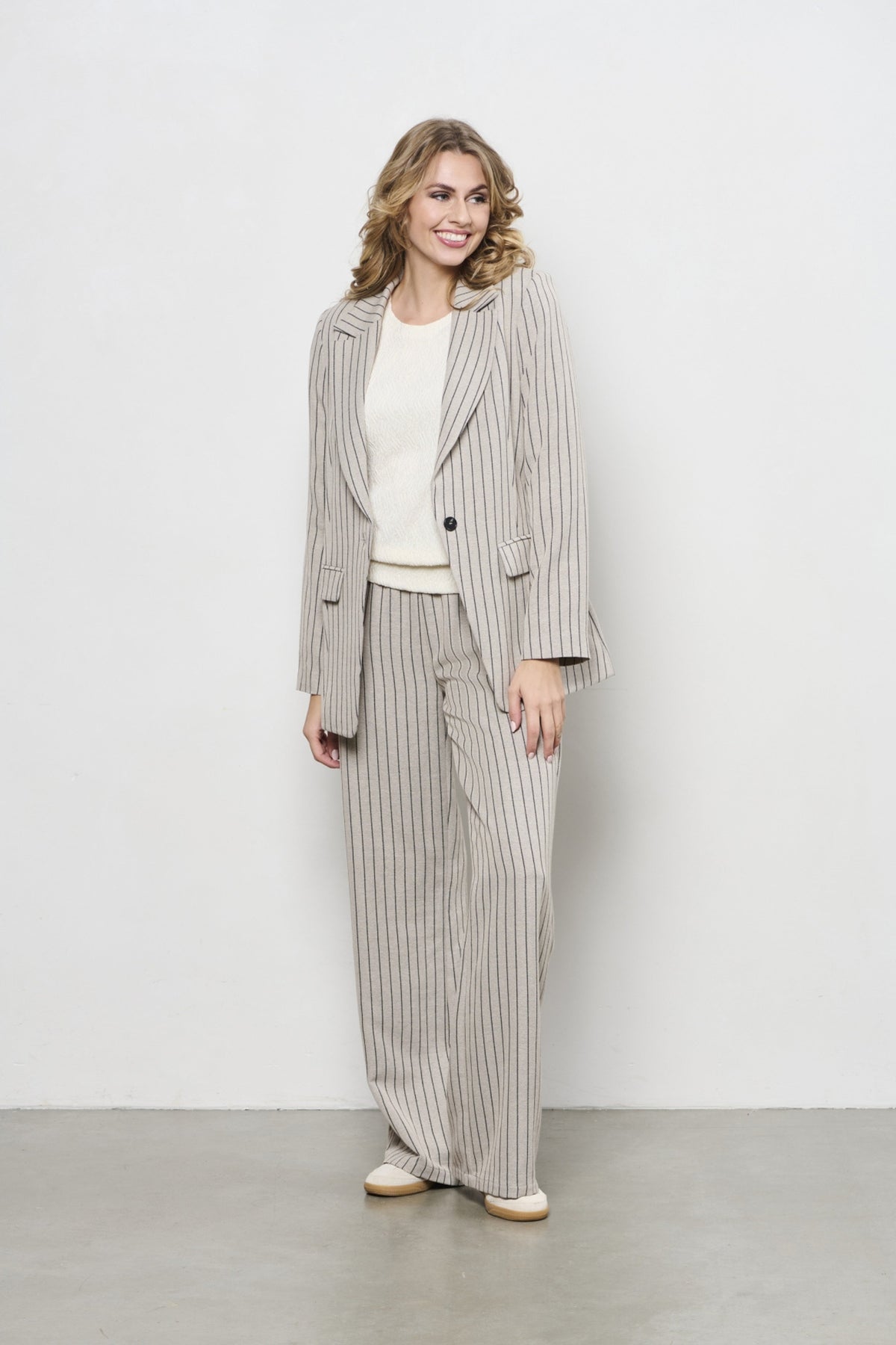 Lichtblauwe en zandkleurige gestreepte blazer voor dames van &Co woman, Marina Stripe Sand Multi, getoond op een model.
