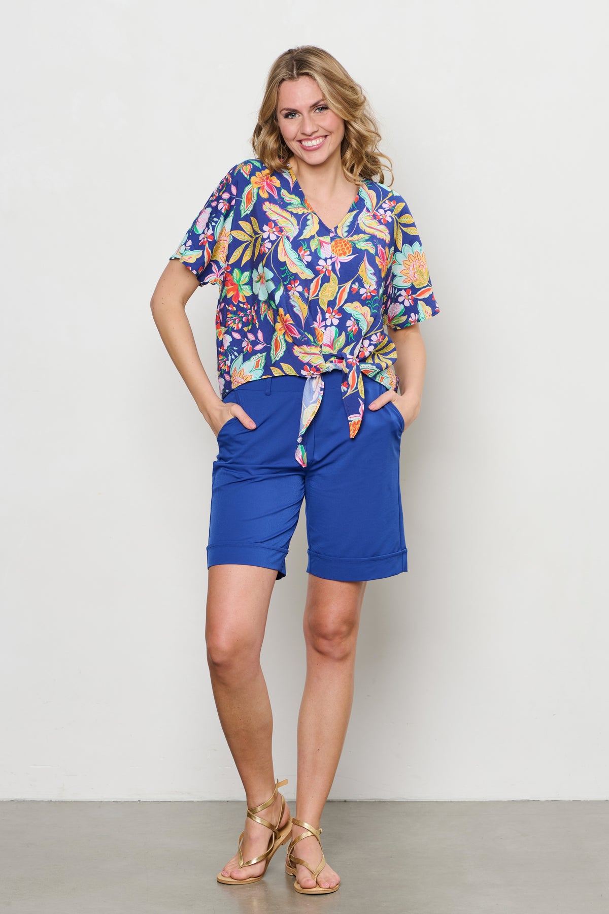 Blouse Aruba Multi Flower van &Co woman, blauwe blouse met kleurrijke bloemenprint, geschikt voor casual en feestelijke gelegenheden.