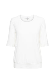 Lichte offwhite top Lucille van &Co woman, casual en stijlvol, met zachte stof en ronde hals, getoond op model.
