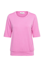 Lichtroze top Lucille van &Co woman, gekleed op een mannequin, met een ronde hals en korte mouwen.