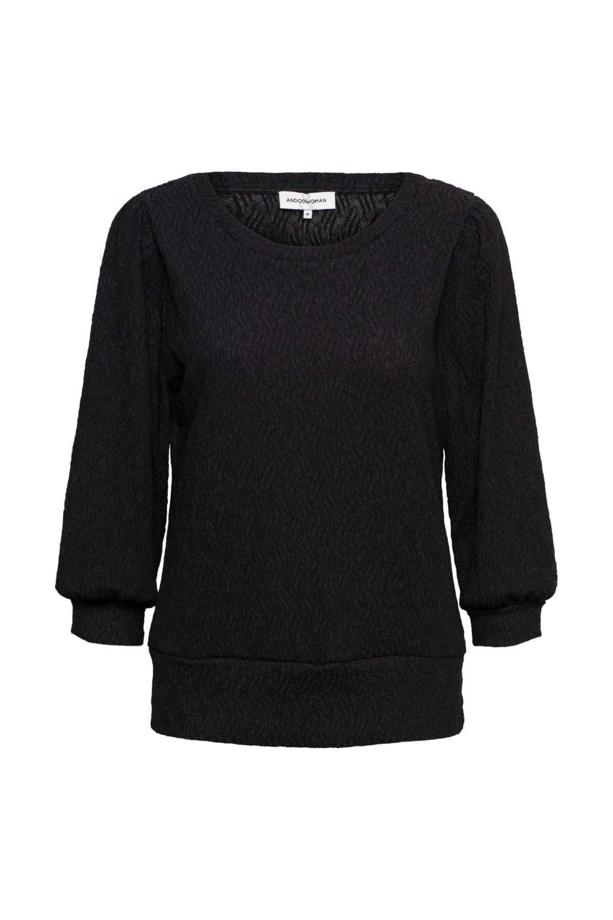 Zwarte top Tyler van &Co woman, getailleerd model met ronde hals en lange mouwen, gedragen door een model.