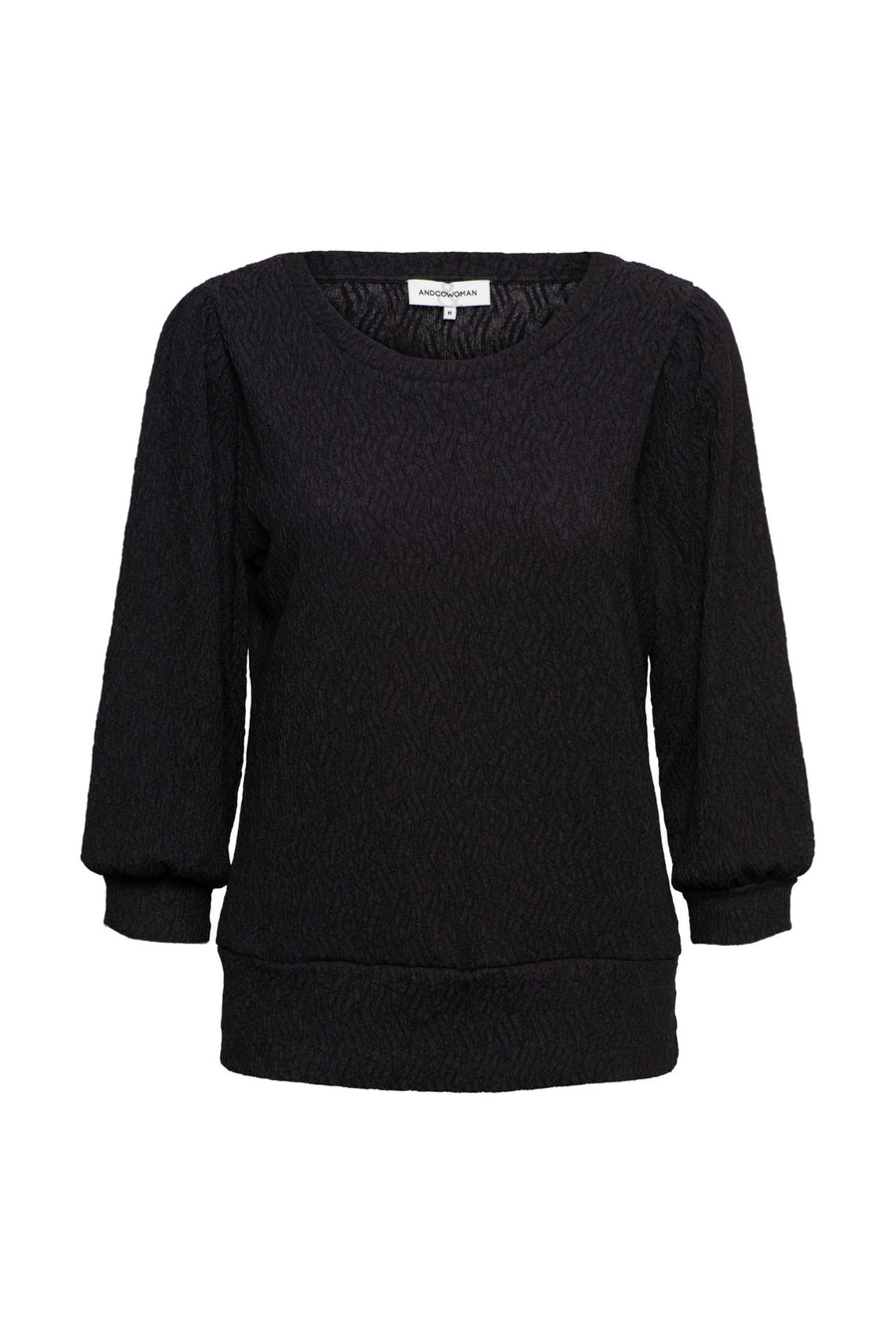 Zwarte top Tyler van &Co woman, getailleerd model met ronde hals en lange mouwen, gedragen door een model.