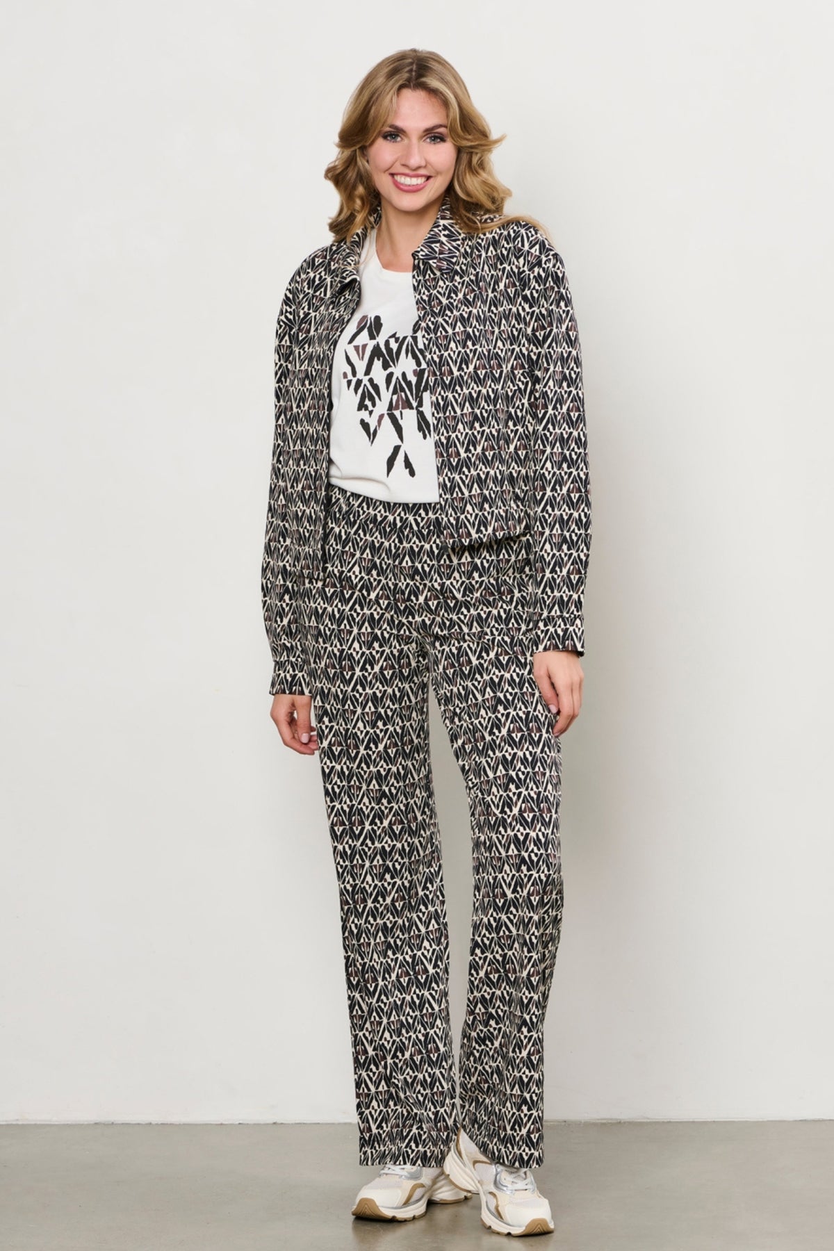 Zwarte en multi-kleurige travel broek Patrice Graphic van &Co woman, comfortabel en stijlvol voor reizen en casual dragen.