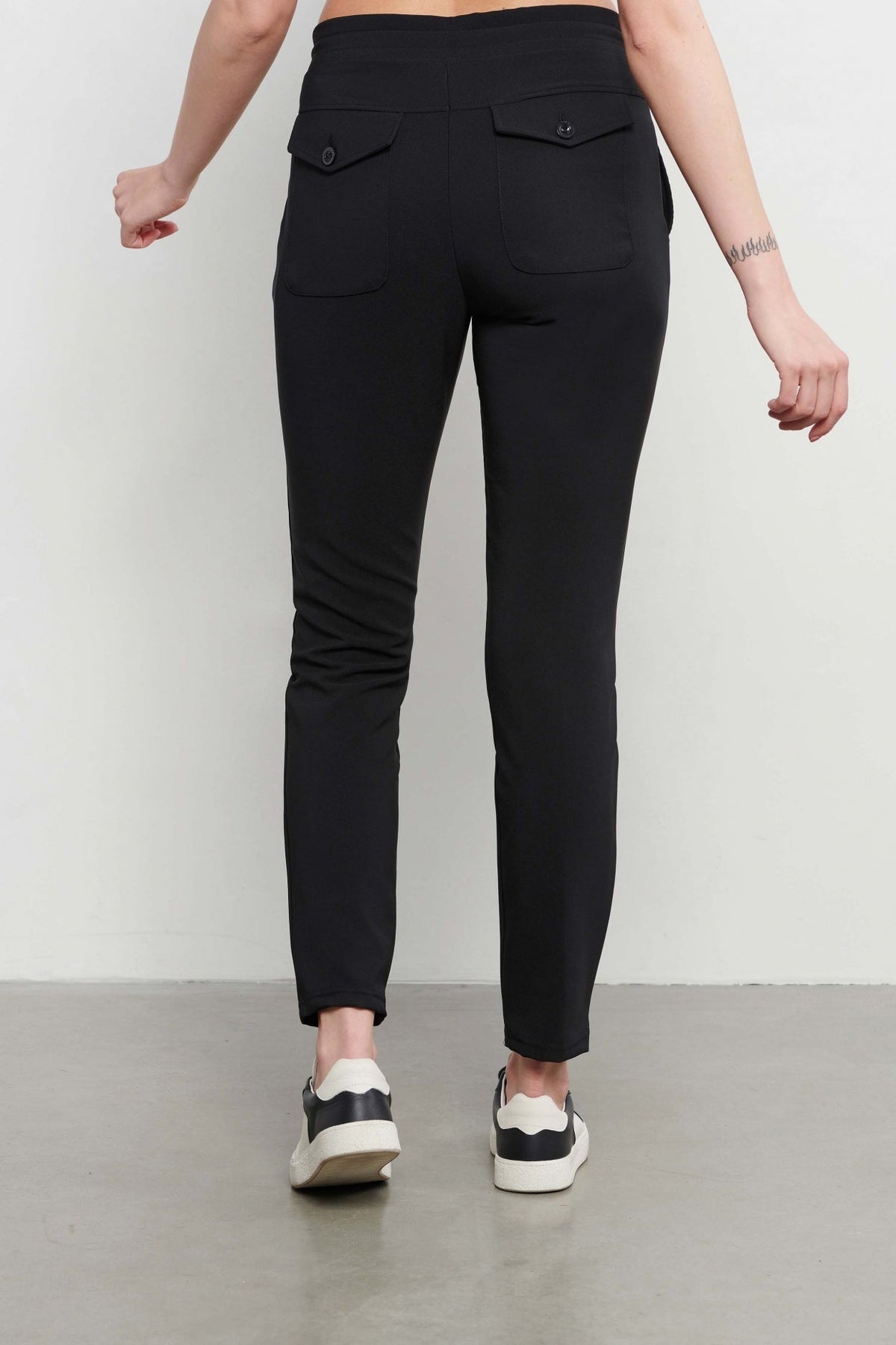 Reisbroek Penny Black PA100-2 van &Co woman, donkerkleurig met comfortabele pasvorm en praktische zakken, gedragen door model.
