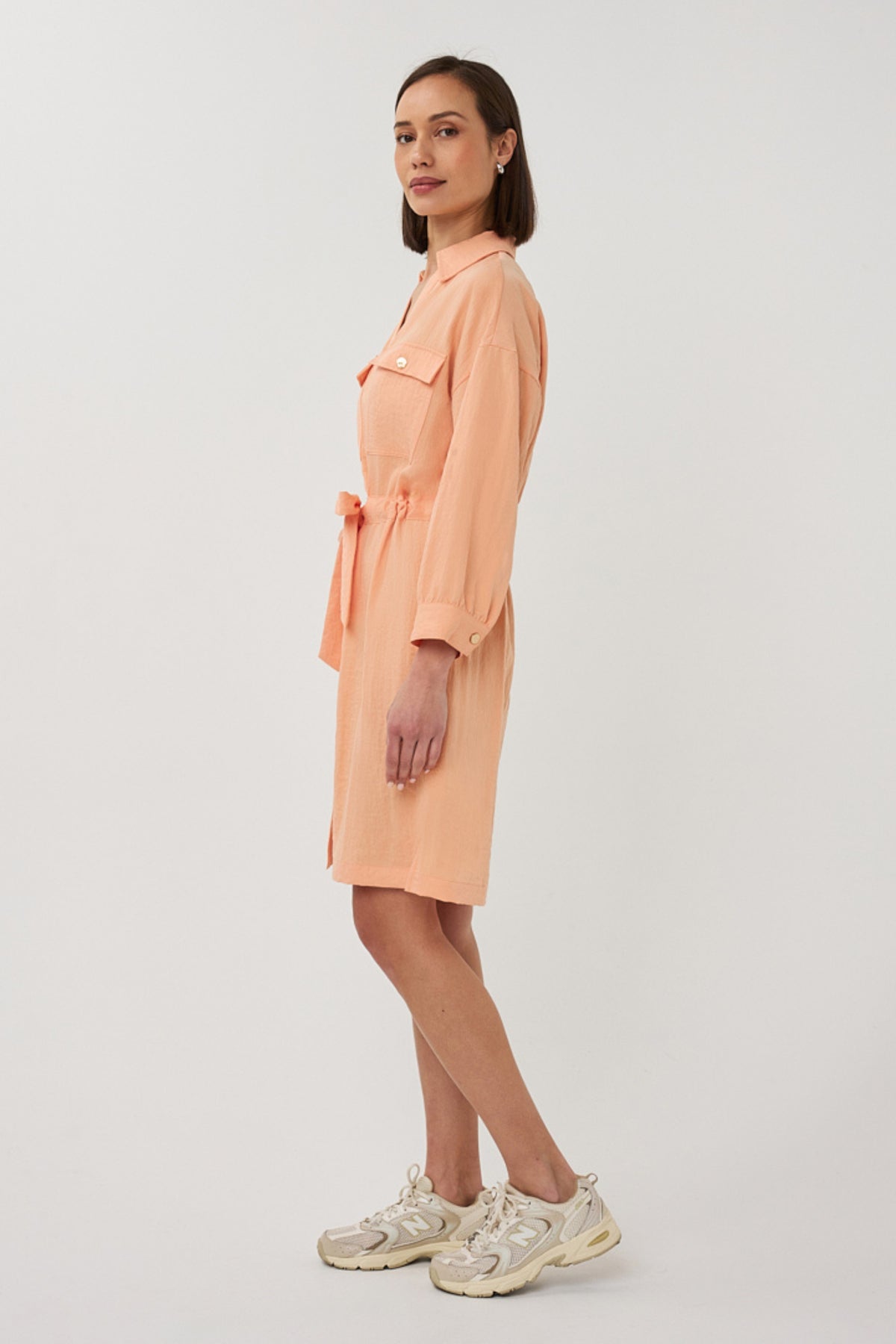 Elegante EsQualo jurk Fine Crinkle Bellini met fijne crinkle structuur en stijlvolle pasvorm, gedragen door een model.