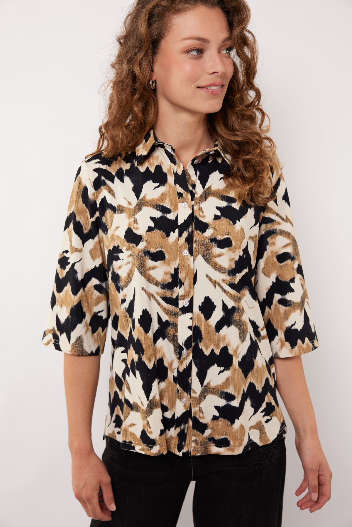 Blouse Uma van G-maxx in licht camel en zwart, soepel vallend met lange mouwen en ronde hals, gedragen door een model.