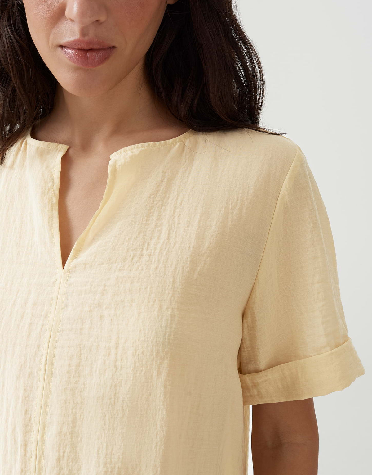 Gele damesblouse Filkara Honey Butter van Opus met knoopdetail en losvallende pasvorm, close-up van de stof en ontwerp.