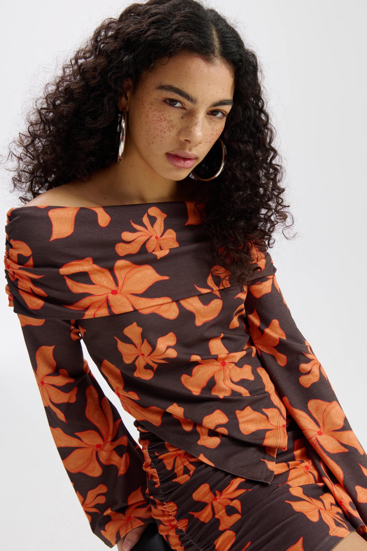 Oranje top Jesse Wild Flower van Harper & Yve, korte mouw en bloemenprint, stijlvolle damesmode, close-up van het ontwerp.