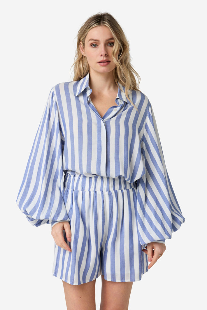 Blauwe korte Shalita Raya van Ibana, geweven met kleurrijke patronen, wordt gedragen als stijlvolle feestjurk of bohemien outfit.