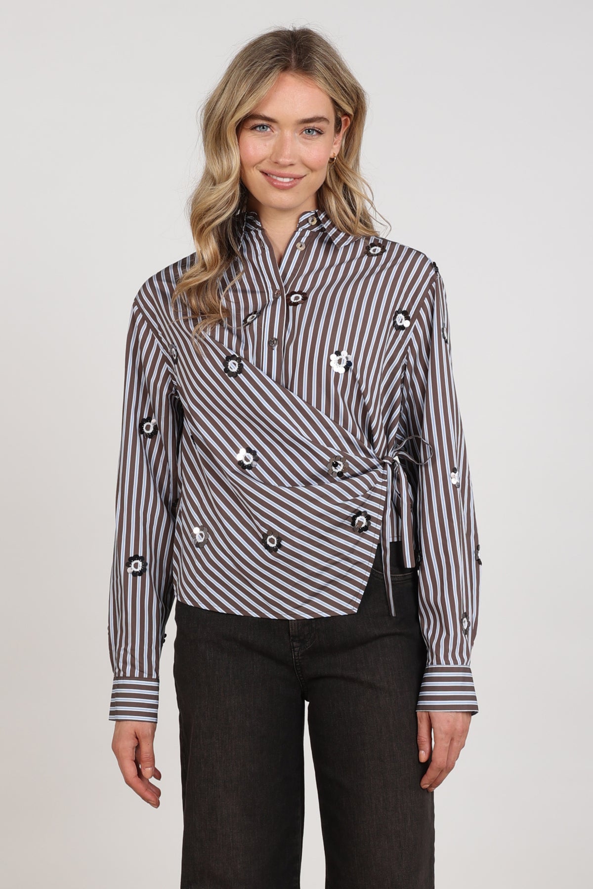Blouse Amy van Nukus met chocoladebruine en skyblauwe strepen, korte mouwen en losse pasvorm, zichtbaar in de afbeelding.
