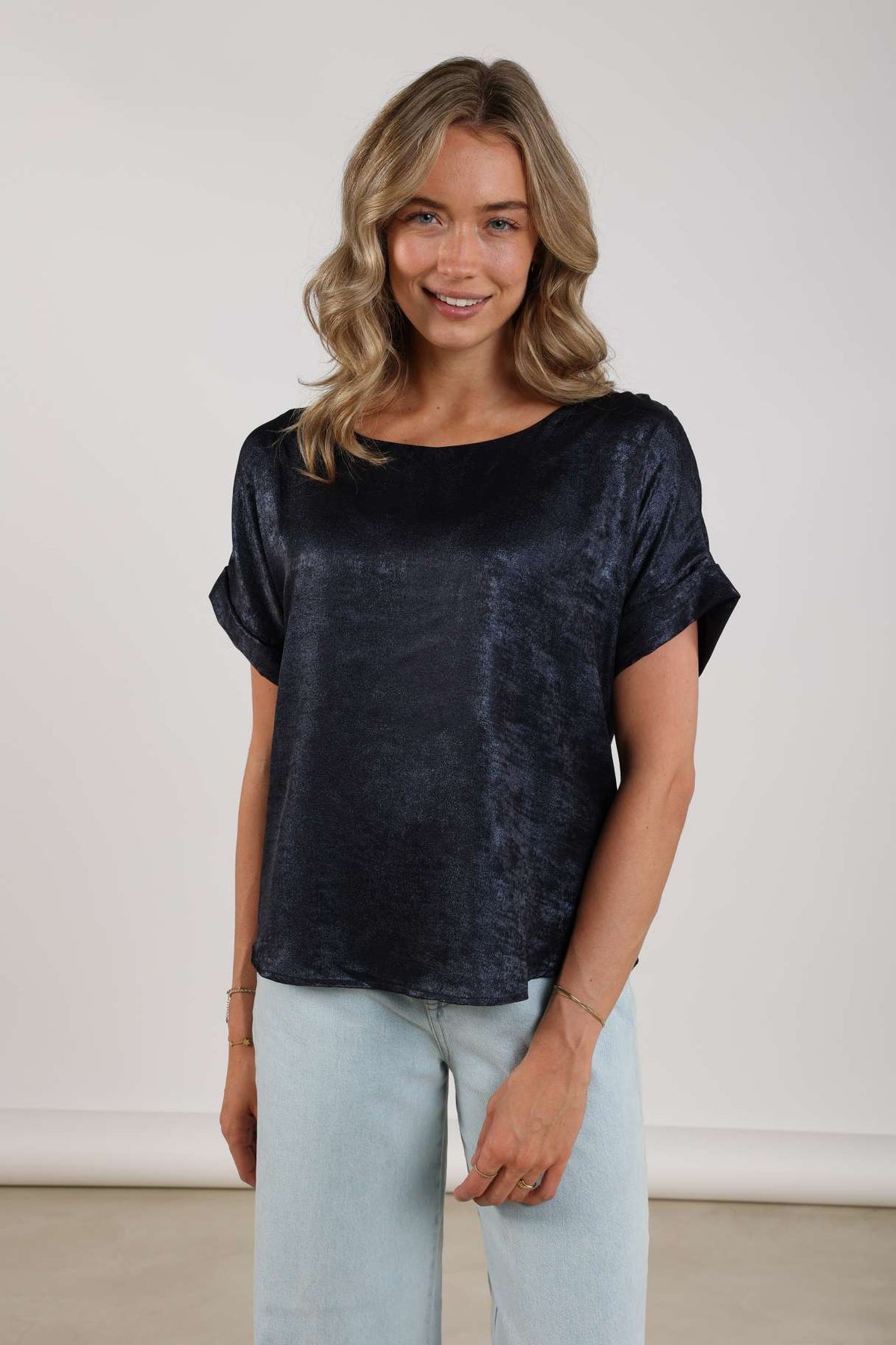 Navy blauw top Irene van Nukus met korte mouwen en ronde hals, gelegen op een witte achtergrond.
