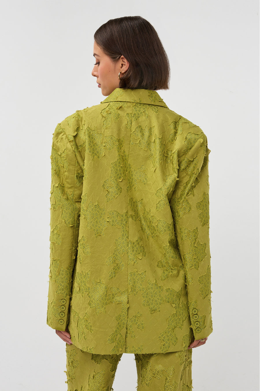 Groene blazer van Studio Amaya, Mio model, getoond op een model met knopen en reverskraag, stijlvolle zakelijke kleding.