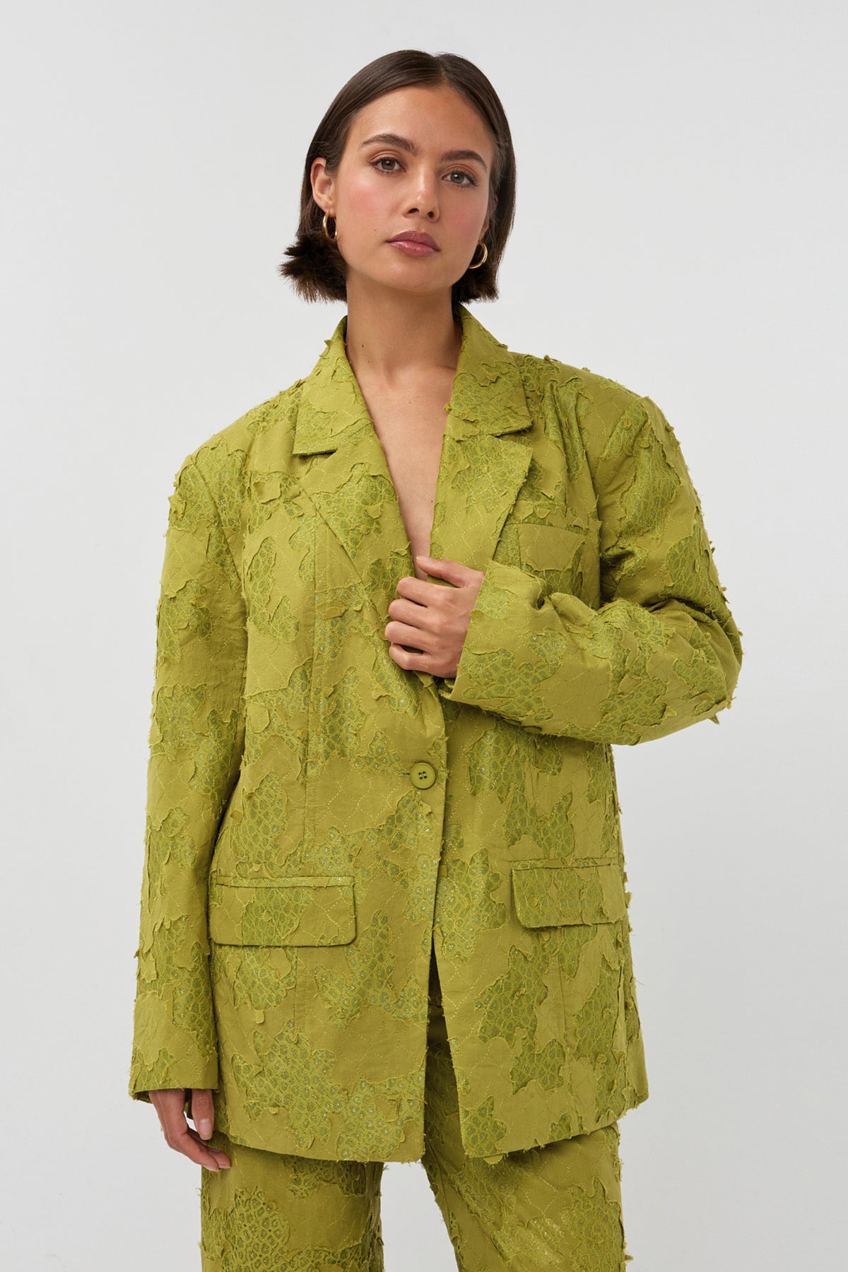 Groene blazer Mio van Studio Amaya, getoond in close-up met knopen en moderne snit.