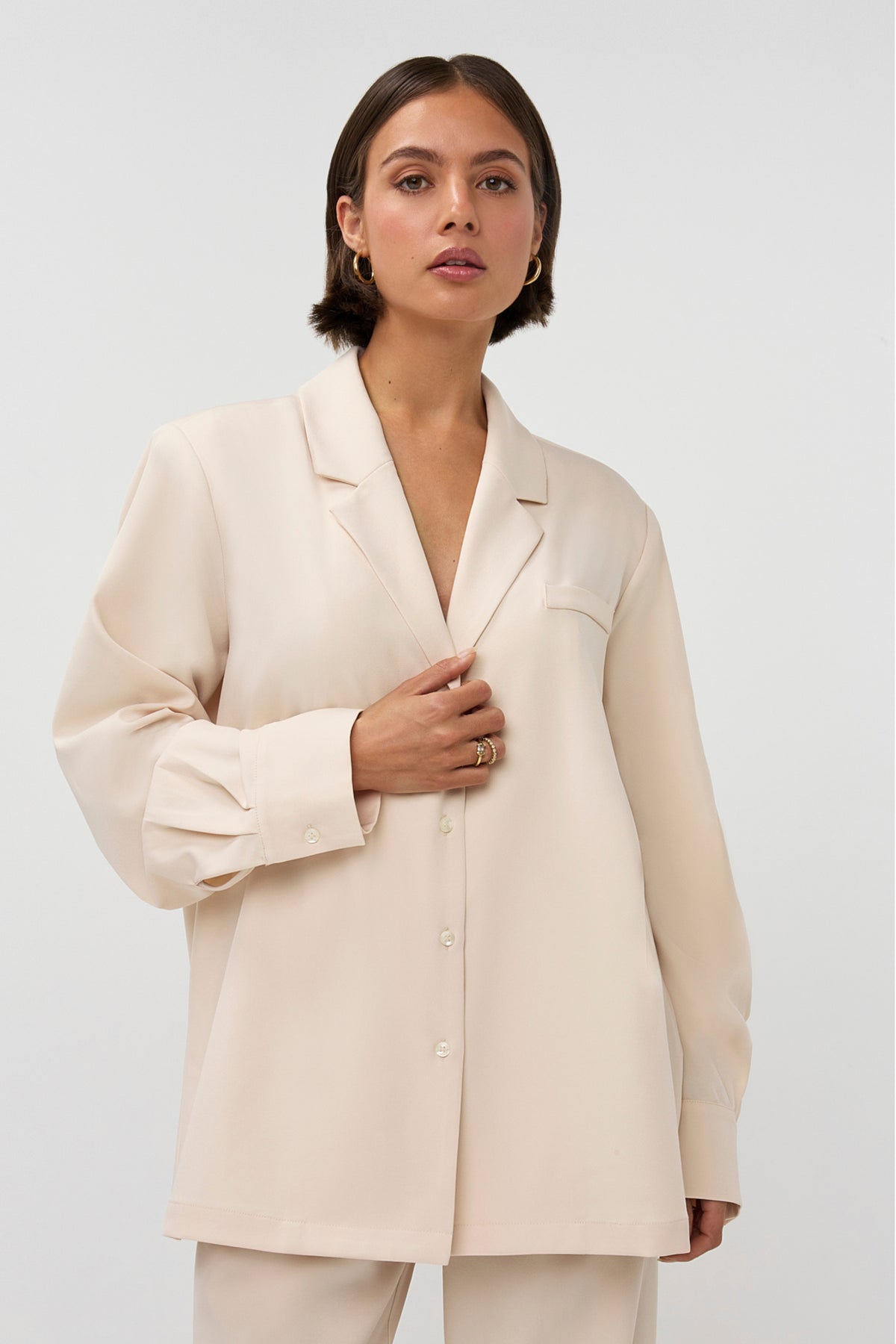 Beige blazer Noomi van Studio Amaya, gedragen door een model, met knopen en reverskraag, voor een stijlvolle uitstraling